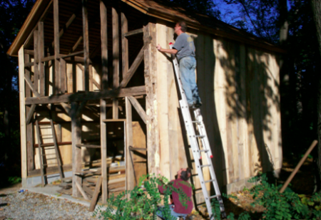 Volunteers Andy Clark (on ladder) and Fred Swartz work on the May Barn restoration in October. 